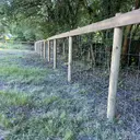 Grillage haut tendu sur piquets bois sous couvert d’arbres
