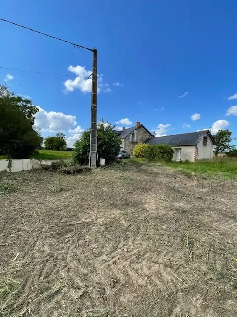 Terrain broyé et dégagé devant une maison en pierre